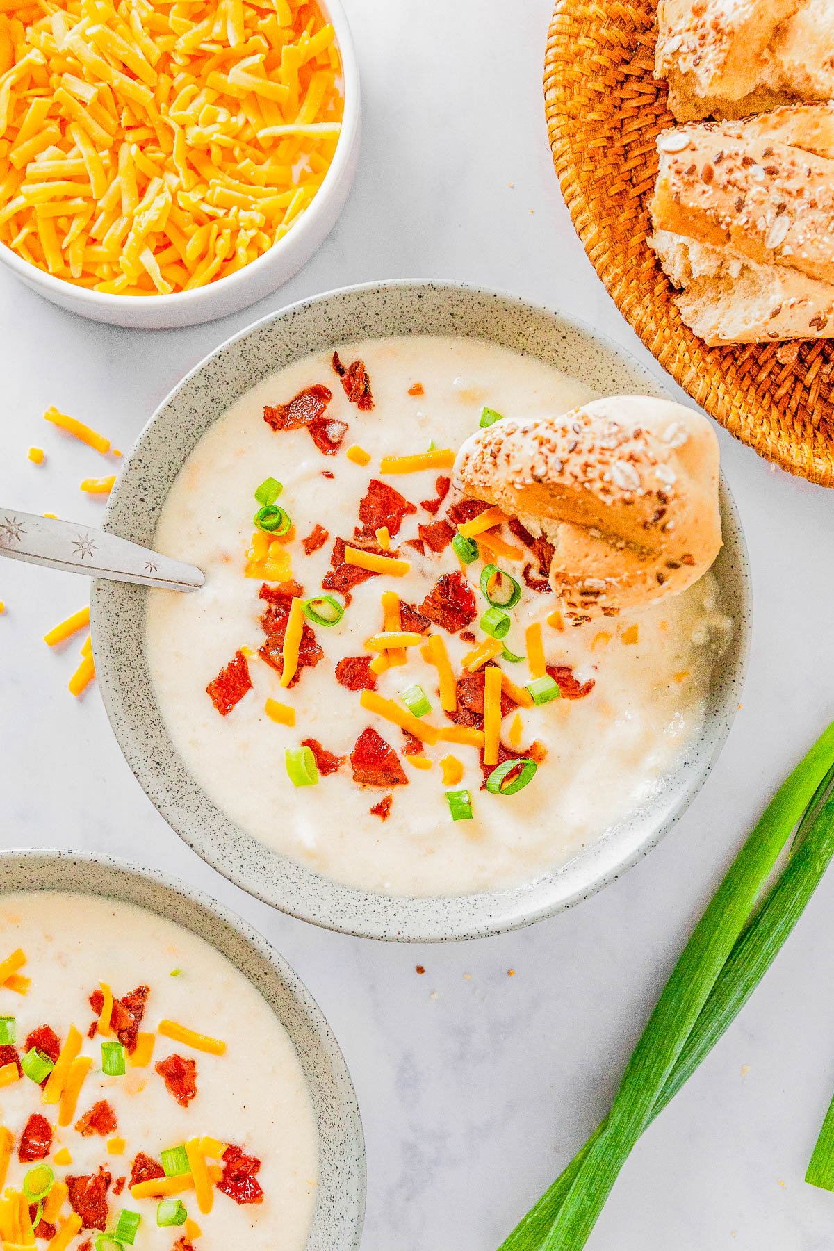 Easy Slow Cooker Potato Soup - This LOADED potato soup is reminiscent of your favorite LOADED baked potato recipe, but conveniently made in your Crock-Pot! In each bite there are tender potatoes amidst a creamy and cheesy broth, topped with crispy bacon bits, green onions, and topped with cheddar cheese for a COMFORT FOOD delight! Easy to make, great for busy weeknights, picky eater approved, and perfect for chilly weather!