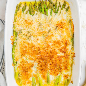 A baking dish of cheesy asparagus casserole with a panko topping.