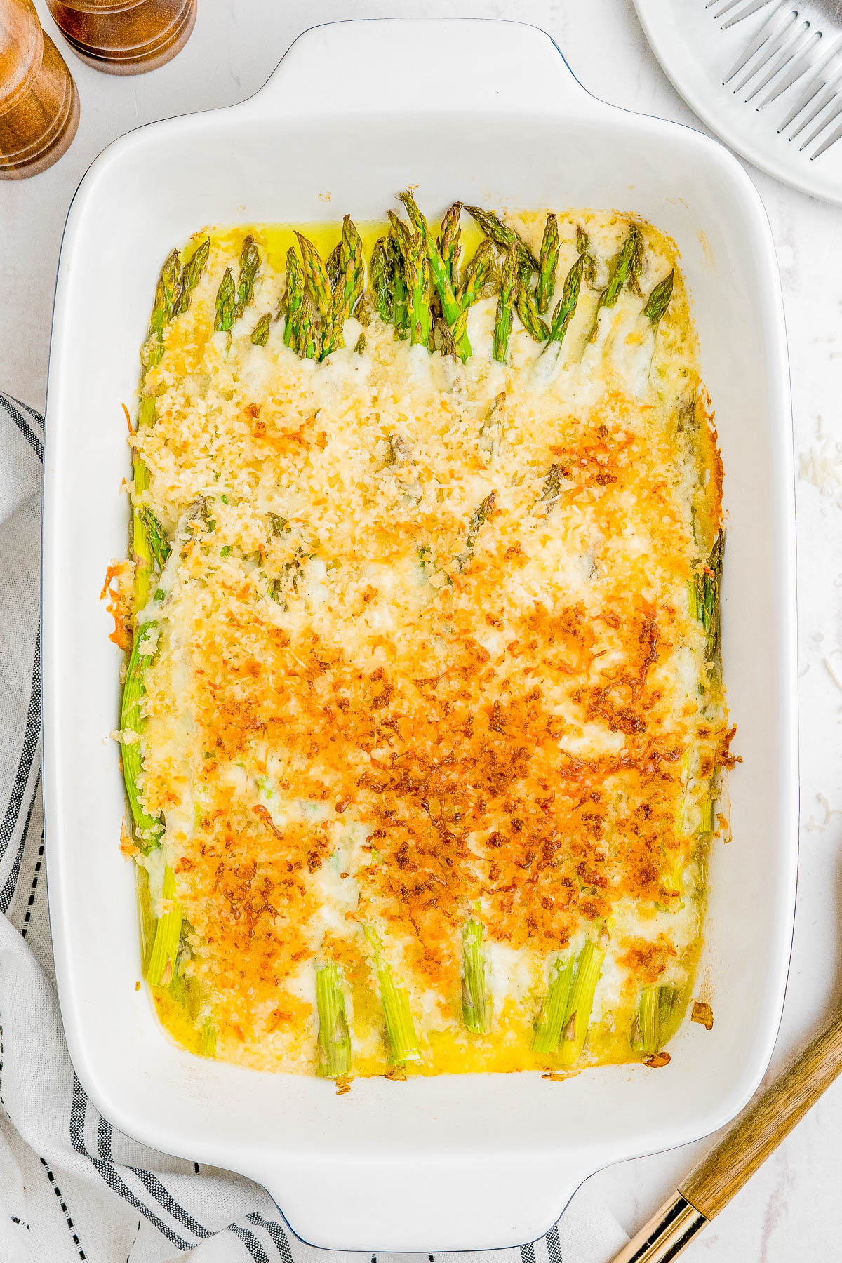 Asparagus Casserole - Smothered in a rich cream sauce, and layered with Parmesan and mozzarella cheeses, along with perfectly crispy breadcrumbs, this will be your new FAVORITE way to eat asparagus! Makes a wonderful holiday side dish from Thanksgiving to Easter, but it's FAST and EASY enough so you can serve it at weeknight dinners!