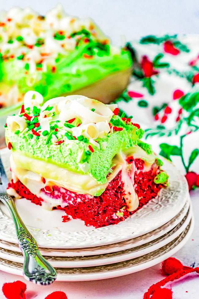 Red Velvet Christmas Cake - The EASIEST and most impressive Christmas cake! You'll have your friends and family thinking you're a rock star pastry chef! Moist red velvet cake is infused with white chocolate pudding, topped with whipped topping, sprinkles, and white chocolate curls! Ready in ONE HOUR and uses shortcut ingredients to make your job as easy and hassle-free as possible! 