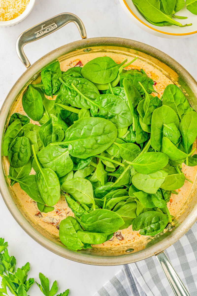 Creamy Garlic Butter Tuscan Salmon - An EASY one-skillet salmon recipe for the most tender and juicy salmon that's bathed in a rich and creamy garlic butter sauce! Parmesan cheese, sun dried tomatoes, and baby spinach add extra flavor and texture to this 30-minute recipe that everyone LOVES! Learn how to make restaurant-worthy salmon that's fast enough for a weeknight dinner but elevated enough to serve to company!