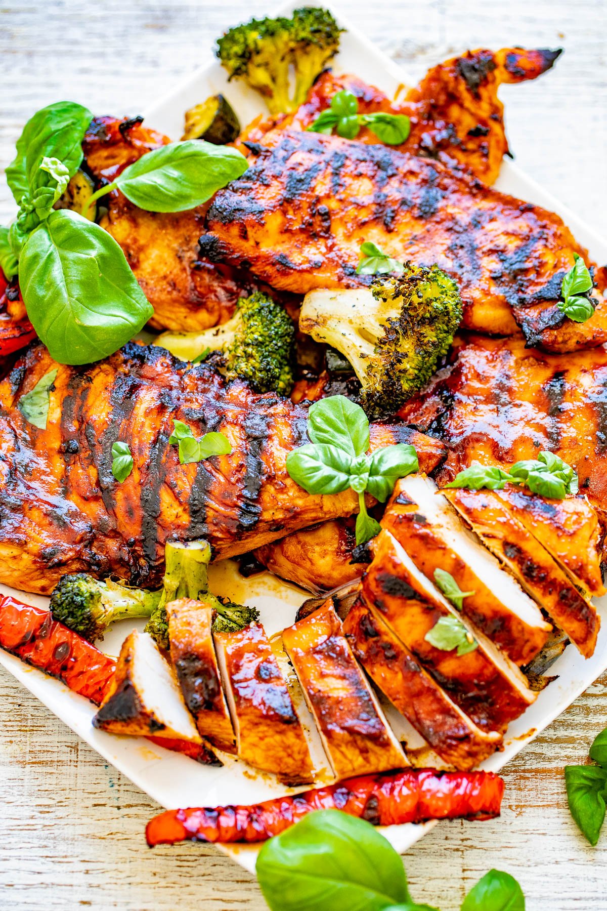 Grilled Sweet and Spicy Basil Chicken - EASY, amazing, PERFECTLY grilled chicken that's sweet-and-spicy with tons of FRESH basil flavor! Learn how to make the BEST grilled chicken and serve it with a side of lightly charred grilled vegetables! Perfect for summer barbecues, picnics, potlucks, and grilling season!ย