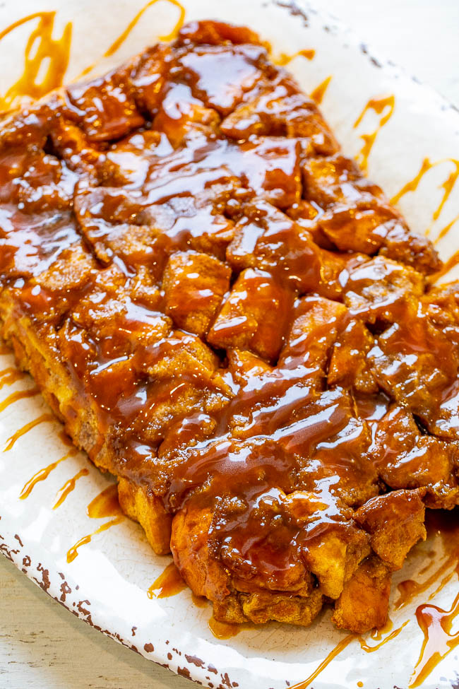 overnight french toast casserole drizzled with caramel sauce on a white platter 