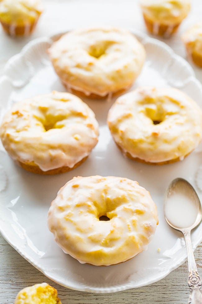 Baked Lemon Donuts with Lemon Glaze - They taste like the Starbucks lemon loaf, but in donut (or mini muffin) form!! Easy, no mixer recipe with a tart-yet-sweet lemon glaze that's PERFECT! Lemon lovers will adore them!!