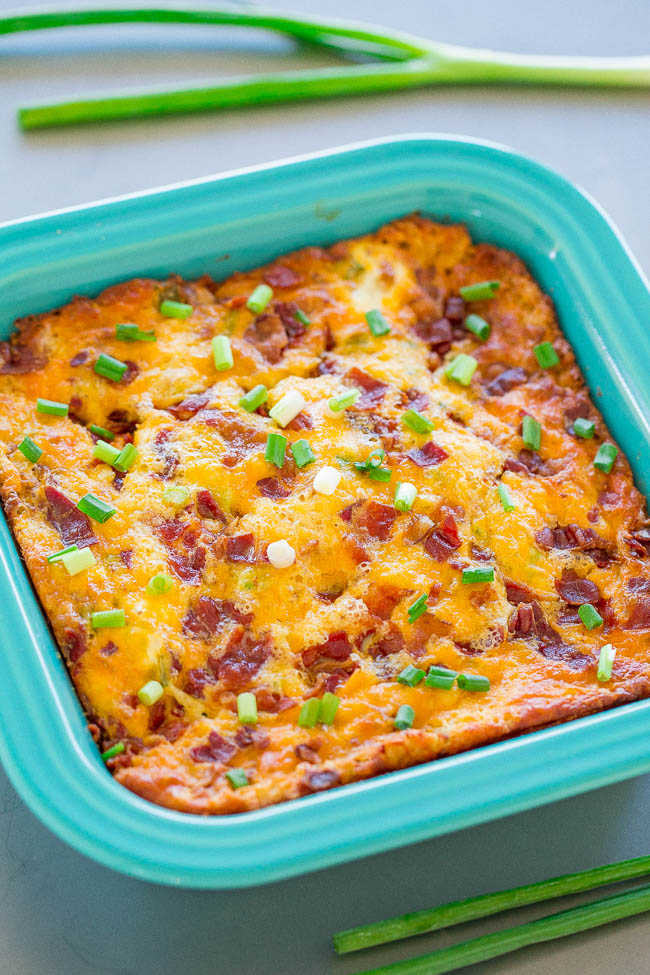 Cheesy Egg Casserole with Bacon garnished with green onions in blue baking dish