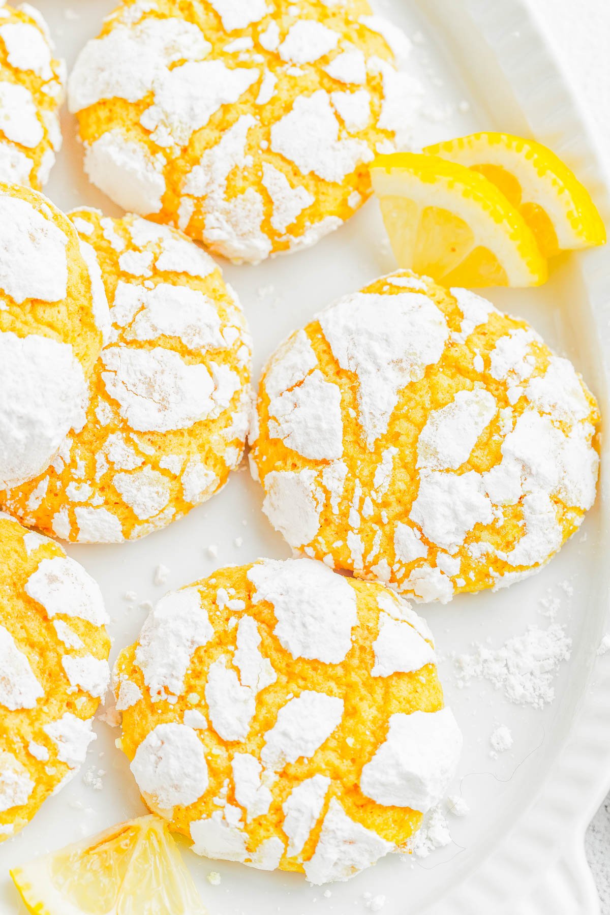 Lemon Crinkle Cookies — Lemon crinkles are pillowy soft on the inside and chewy on the outside, with slightly crispy edges from the powdered sugar coating! They taste like lemon bars, but in cookie form! The dough is flavored with lemon three ways and is perfect for holiday gatherings, Easter, Mother’s day, or whenever you’re craving an EASY lemon dessert 🍋!