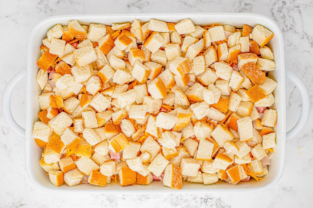 A baking dish filled with cubed pieces of bread, presumably being prepared for baking or as part of a recipe.