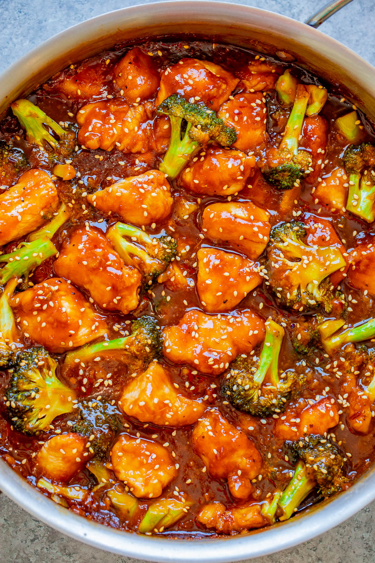 A dish of sesame chicken with broccoli in a thick, glossy sauce.