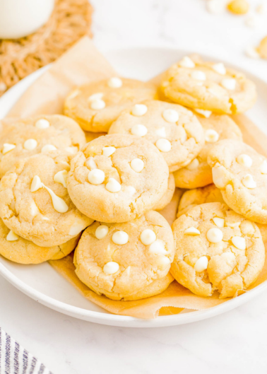 Plate of white chocolate chip cookies on a kitchen counter.