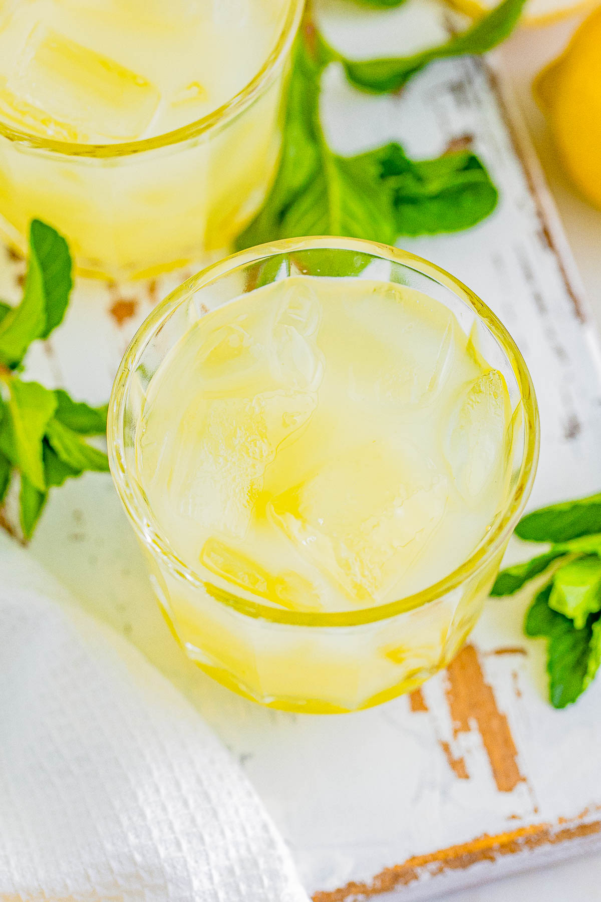 A glass of limoncello spritz garnished with fresh mint leaves.