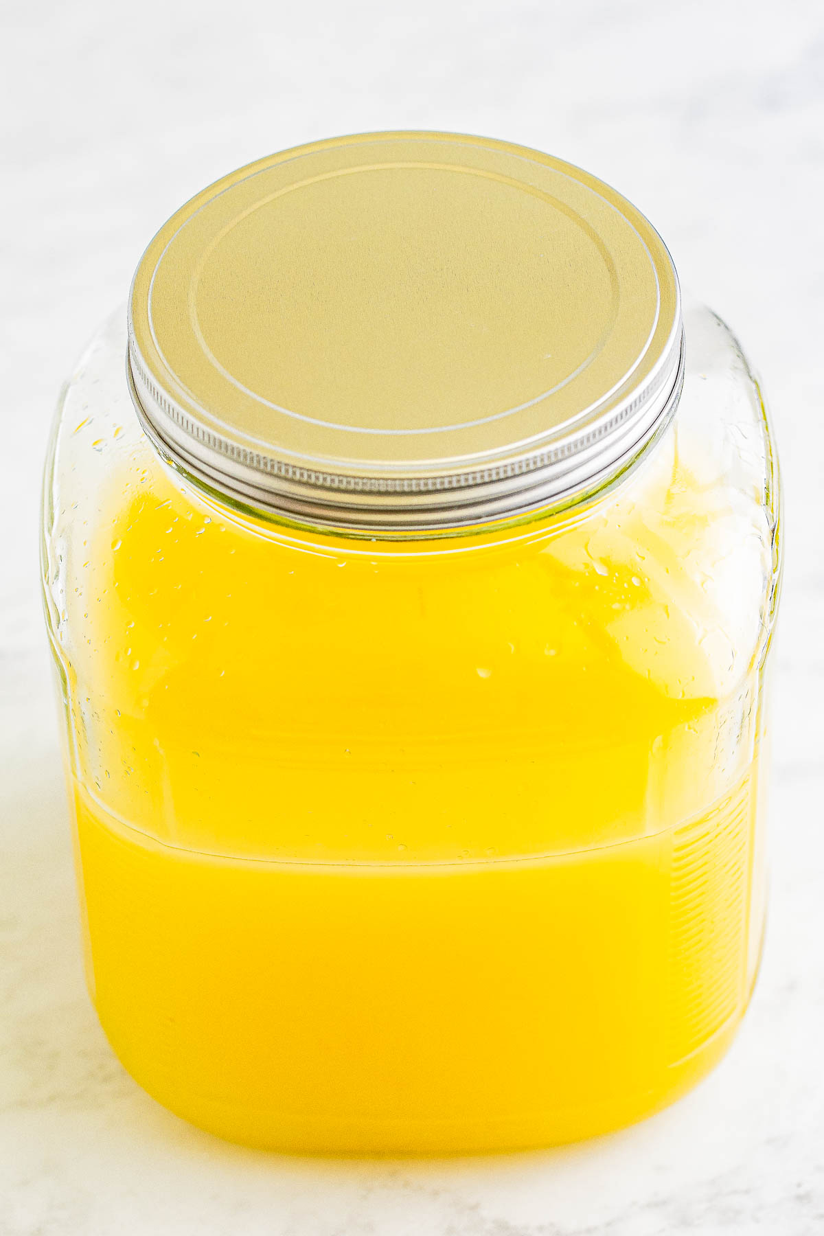 A sealed glass jar filled with freshly made limoncello.