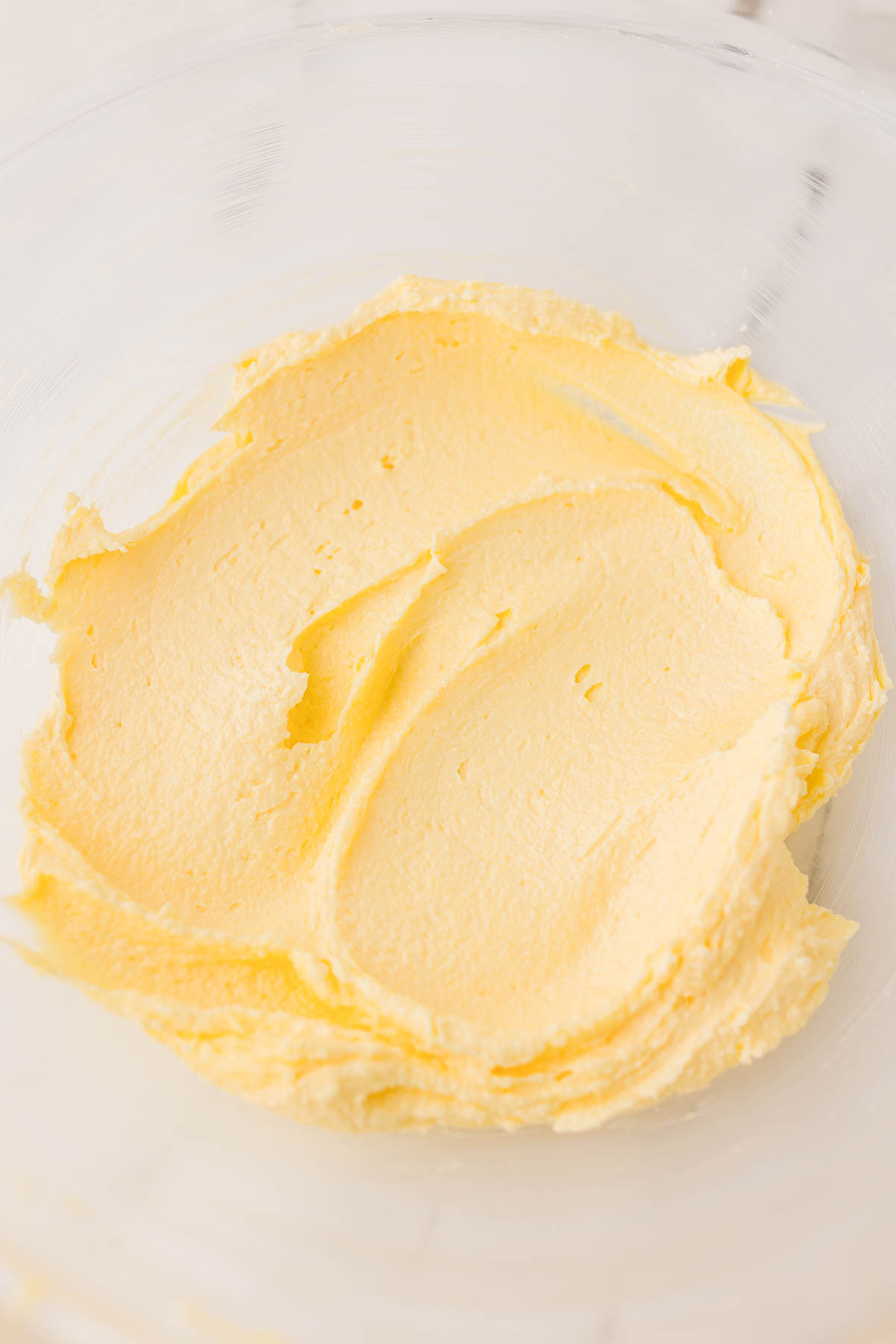 A glass bowl containing creamed butter and sugar, mixed until light and fluffy.