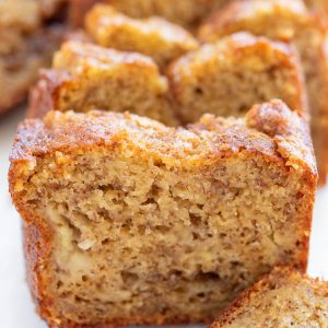 Close-up of sliced banana bread showing a moist, dense texture with visible bits of banana inside.
