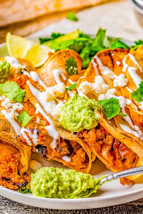 Cauliflower Tinga Tacos with Avocado Crema - Roasted cauliflower is drenched in a smoky, perfectly spicy chipotle sauce, then folded into corn tortillas, cheese is added, and baked to crispy perfection! A bright avocado crema sauce is the finishing touch! Naturally gluten-free vegetarian food never tasted so AMAZING! You'll never miss the meat in these healthy tacos!