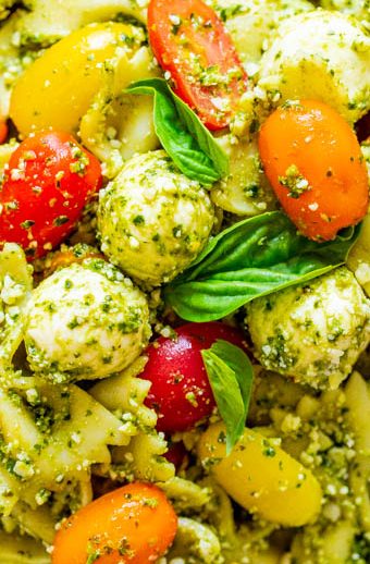 Tomato and Mozzarella Pesto Pasta Salad - Tender pasta, cherry tomatoes, and fresh mozzarella are coated in Parmesan cheese and DELICIOUS pesto sauce!! EASY, ready in 15 minutes, and great for easy meals with planned leftovers or for parties because it feeds a crowd!!