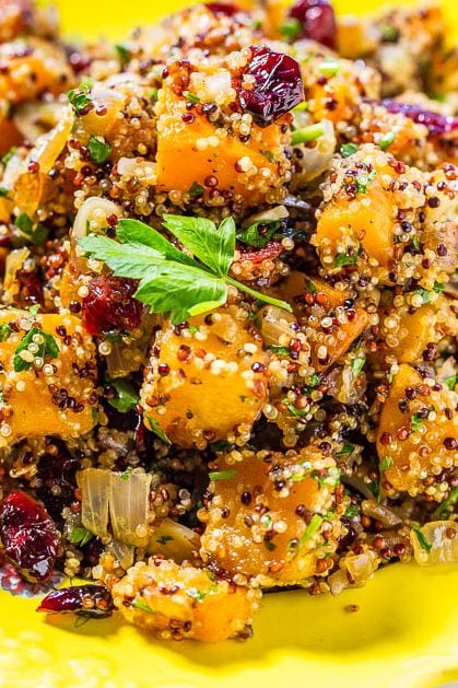 butternut squash quinoa salad with cranberries in a yellow dish.