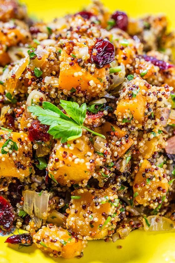 butternut squash quinoa salad with cranberries in a yellow dish.